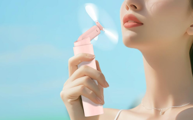 a Person Using Handheld Mini Fan a Person Using Handheld Mini Fan