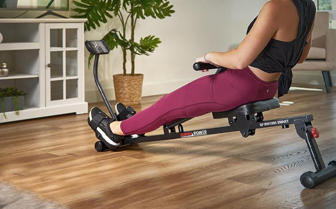 A Person Using the Sunny Health Fitness Compact Adjustable Rowing Machine A Person Using the Sunny Health Fitness Compact Adjustable Rowing Machine