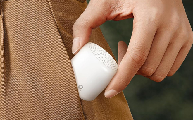 A Person putting a White Noise Sound Machine in their Pocket A Person putting a White Noise Sound Machine in their Pocket