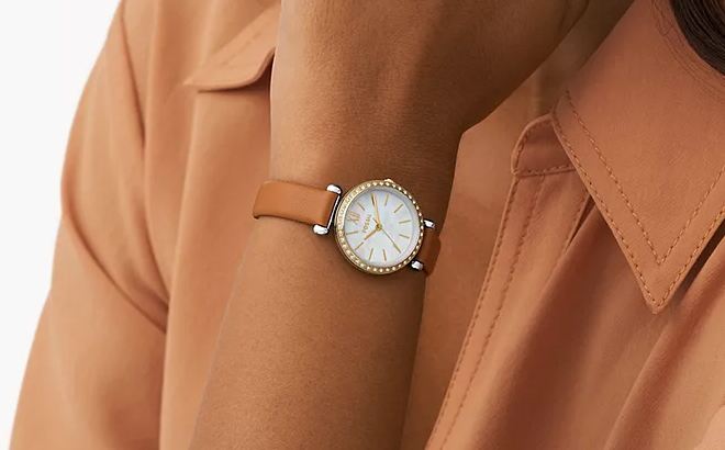 A person wearing a Fossil Tillie Mini Three Hand Brown Leather Watch