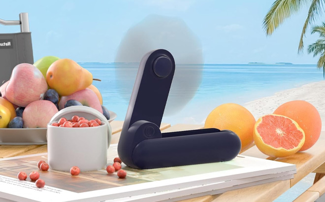 Handheld Mini Fan in Dark Blue Color on the Table Handheld Mini Fan in Dark Blue Color on the Table