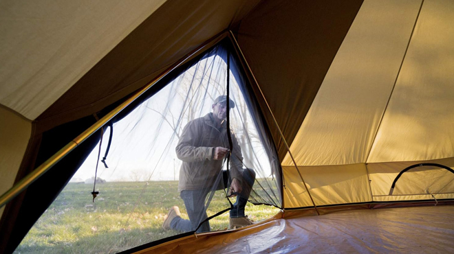 A Person Zipping up the Net door of Teton Sports Canvas Tent A Person Zipping up the Net door of Teton Sports Canvas Tent