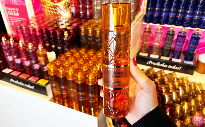 A person holding a bottle of Bath Body Works Getaway Soiree Fragrance Mist A person holding a bottle of Bath Body Works Getaway Soiree Fragrance Mist