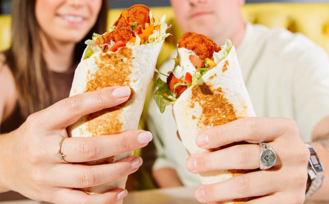 A Couple Holding Taco Bell Burritos A Couple Holding Taco Bell Burritos