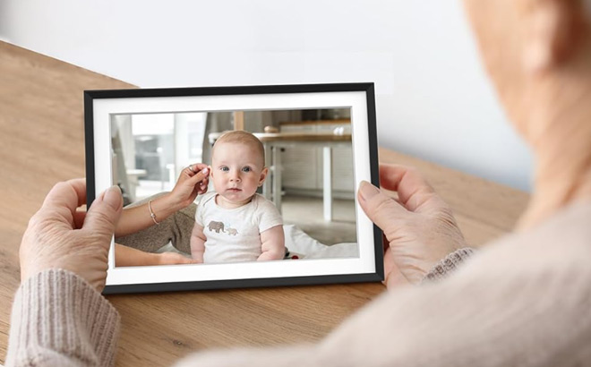 A Grandmother Looking at Her Grandchild on a Digital Picture Frame A Grandmother Looking at Her Grandchild on a Digital Picture Frame