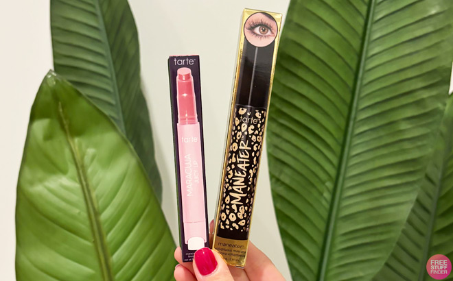 A Woman Holding Tarte Maneater Mascara and Maracuja Juicy Lip Balm A Woman Holding Tarte Maneater Mascara and Maracuja Juicy Lip Balm