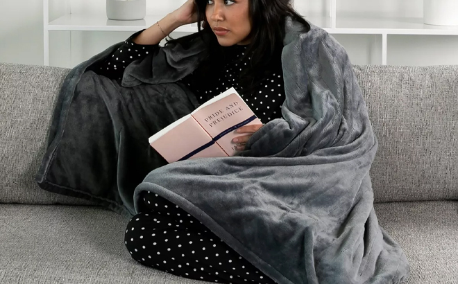A Person Wearing the Brookstone Heated Cozy Throw in Grey A Person Wearing the Brookstone Heated Cozy Throw in Grey