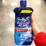 A person holding a Finish Jet Dry Rinse Aid 32 oz