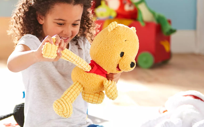 A Girl Playing with the Winnie the Pooh Disney Blissful Buddies Fidget Plush