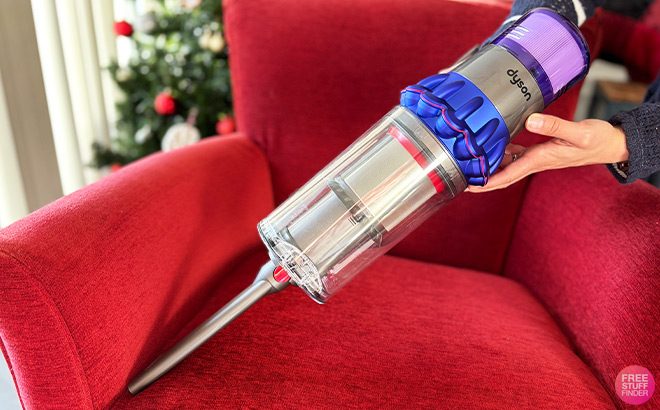 A Person Cleaning Chair with Vacuum A Person Cleaning Chair with Vacuum