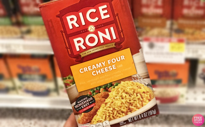 A Person Holding a Box of Rice A Roni Creamy Four Cheese