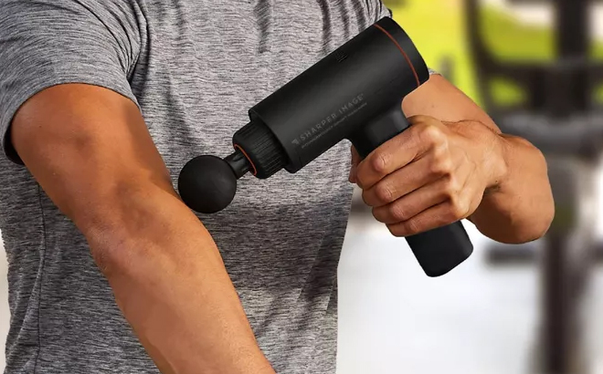 A Person Using the Sharper Image Powerboost Sport Percussion Handheld Massager A Person Using the Sharper Image Powerboost Sport Percussion Handheld Massager