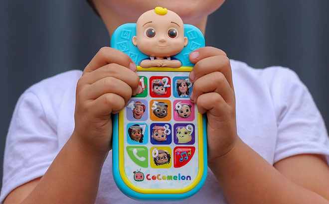 A Person holding a CoComelon JJs First Learning Toy Phone