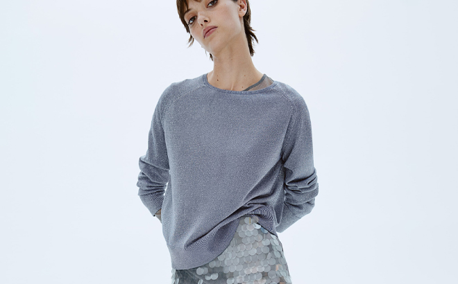 A Person wearing an HM Glittery Sweater