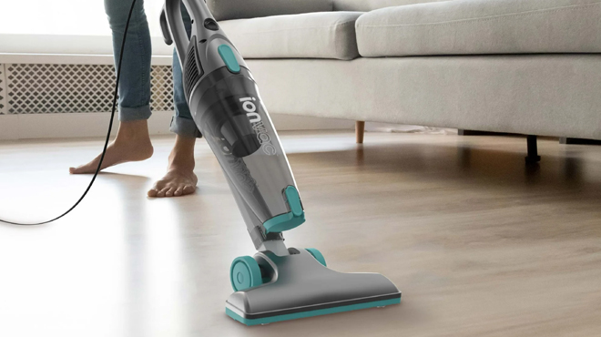 A person cleaning a living room using Ionvac ZipVac 3 in 1 Corded Vacuum