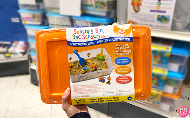 A person holding a Creativity for Kids Sensory Bin Construction Zone