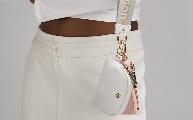 A person holding a Lululemon Dual Pouch Wordmark Wristlet