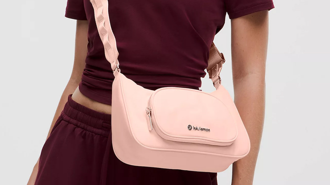A person slinging a Lululemon Crossbody Bag with Nano Pouch 2L A person slinging a Lululemon Crossbody Bag with Nano Pouch 2L