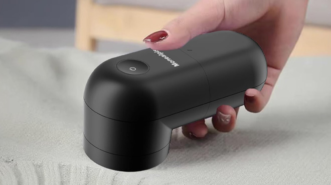 Hand holding Monealpis Fabric and Lint Shaver Hand holding Monealpis Fabric and Lint Shaver