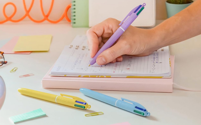 A Person Writing with BIC 4 Color Ballpoint Pens