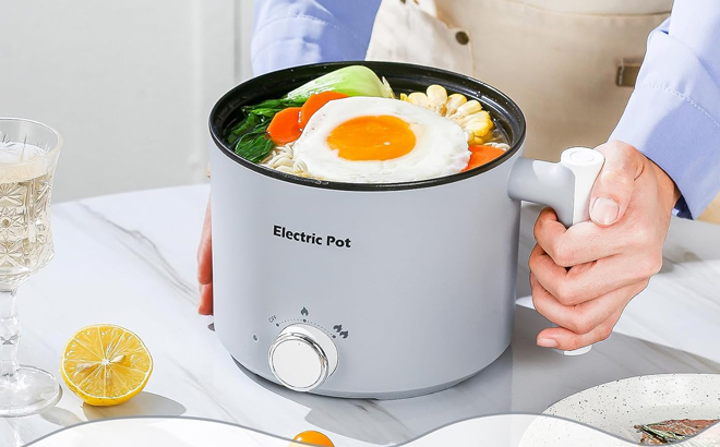 A Woman Holding the YOOLYQI Electric Hot Pot A Woman Holding the YOOLYQI Electric Hot Pot
