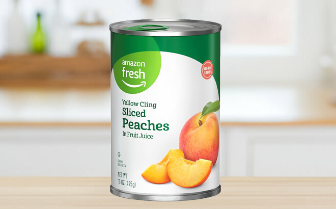 A Can of Amazon Fresh 15 Ounce Yellow Cling Sliced Peaches on a Table A Can of Amazon Fresh 15 Ounce Yellow Cling Sliced Peaches on a Table