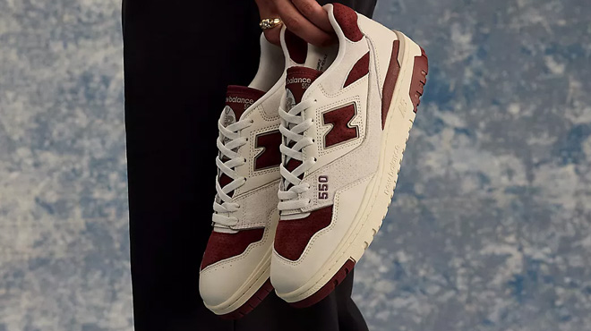 A Man Holding a Pair of New Balance 550 Shoes