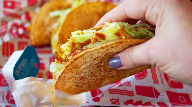 A hand holding Jack in the Box Taco A hand holding Jack in the Box Taco