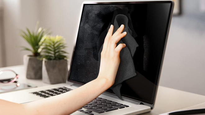 A person cleanind a computer screen using Eveo Screen Cleaner A person cleanind a computer screen using Eveo Screen Cleaner
