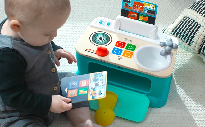 A Baby playing with Baby Einstein Hape Magic Touch Kitchen