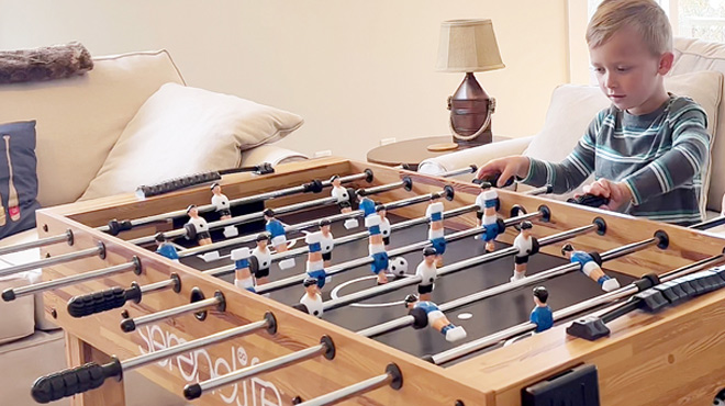 A Boy Playing on the SereneLife Competition Sized Foosball Table