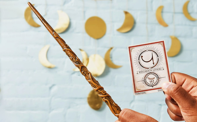 A Person Holding Wizarding World Hermione Granger Spellbinding Wand and Spell Card