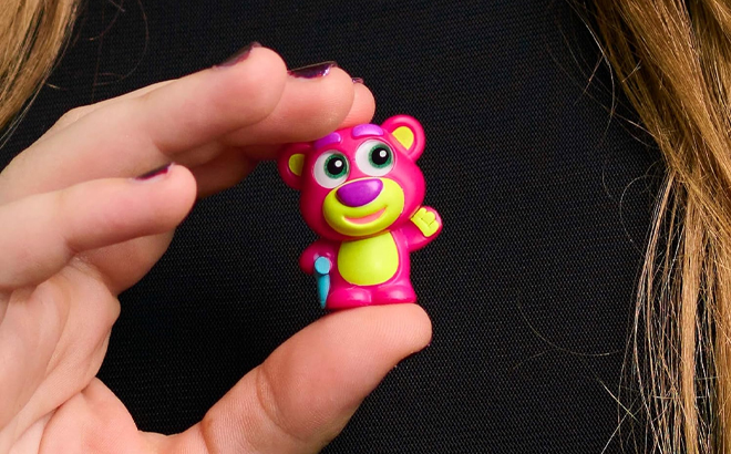 A Person Holding a Neon Disney Doorables Figurine A Person Holding a Neon Disney Doorables Figurine