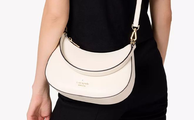 A Person wearing Kate Spade Outlet Paige Convertible Crossbody Bag in Meringue Color