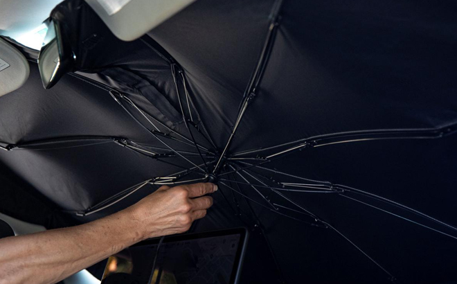 A Woman Installing the Brellashade Pop Up Windshield Sun Shade Umbrella