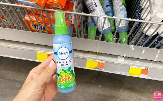 A Hand holding Febreze Fabric To Go Gain Refresher Spray A Hand holding Febreze Fabric To Go Gain Refresher Spray