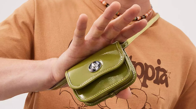 A Man Holding Coach Outlet Wavy Wallet In Crinkle Patent Coachtopia Leather