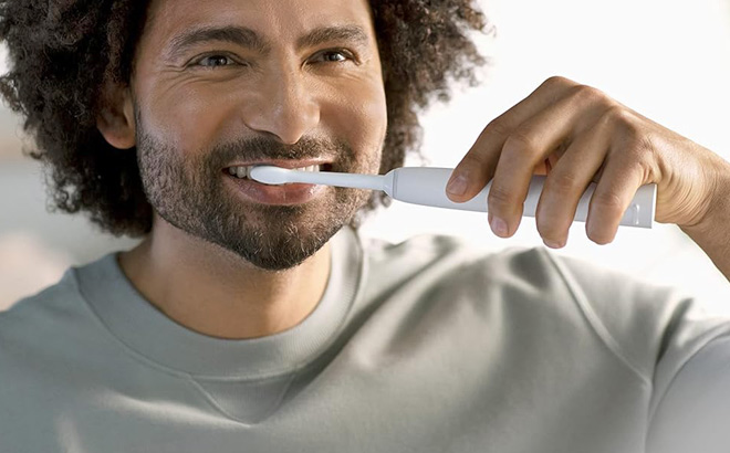 A Person Using Philips Sonicare Electric Toothbrush A Person Using Philips Sonicare Electric Toothbrush