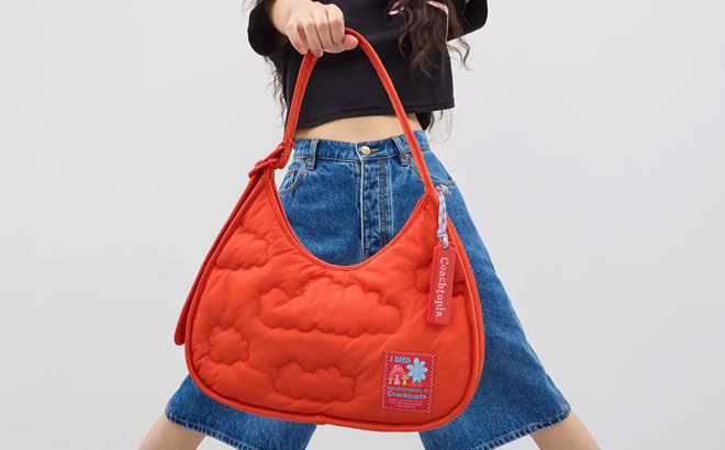 A Woman Holding Coach Outlet Coachtopia Loop Ergo Bag With Cloud Quilting