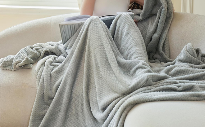 A Woman Sitting Covered with the DaysU Throw Fleece Blanket
