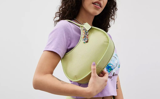 A Woman Wearing Coach Outlet Ergo Bag In Coachtopia Leather