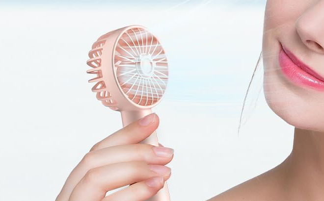 A Hand holding Kidee Portable Handheld Fan in Rose Pink Color A Hand holding Kidee Portable Handheld Fan in Rose Pink Color