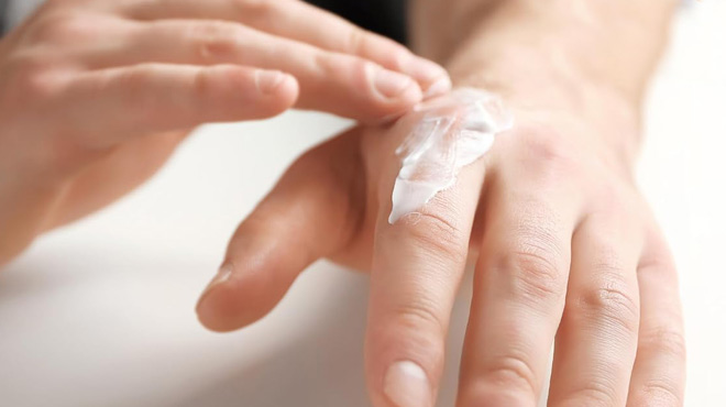 A Person Applying Gold Bond Mens Essentials Lotion on Their Hand
