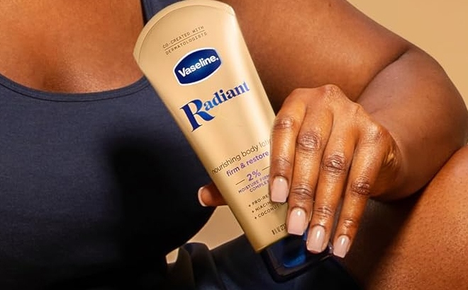 A Person Holding the Vaseline Radiant X Firm Restore with Pro Retinol Niacinamide Coconut Oil Nourishing Body Lotion 8 oz