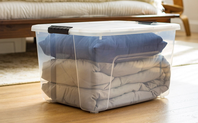 Iris 60 Quart Plastic Storage Bin with Lid on a Floor