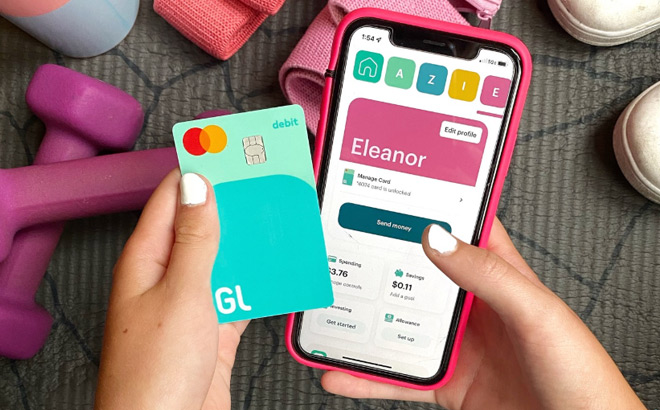 A Girl Holding Her Phone and Greenlight Debit Card A Girl Holding Her Phone and Greenlight Debit Card