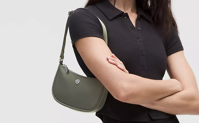 A Person wearing Lululemon City Essentials Mini Shoulder Bag 1L in Grey Sage Color