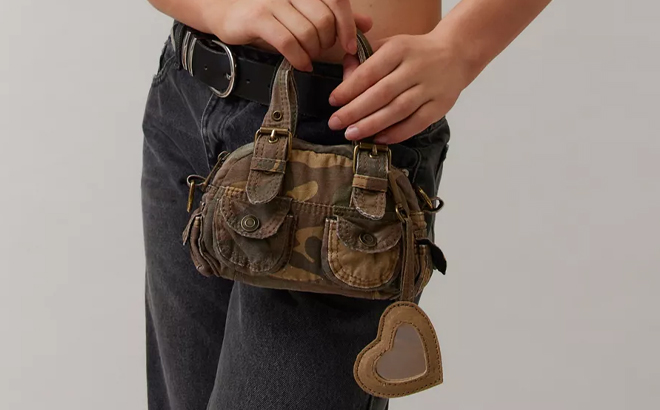 A Woman Holding BDG Mini Denim Duffle Crossbody Bag