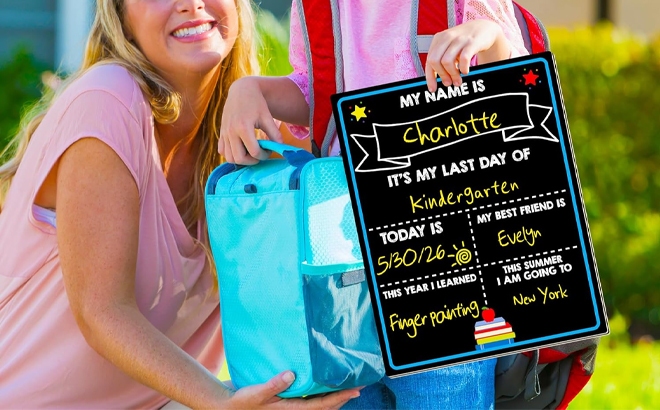 A Child with Mother Holding a First and Last Day of School Chalkboard