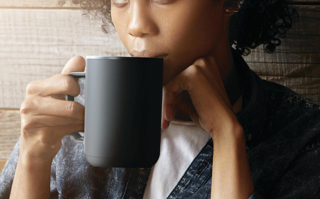 A Person Drinking from an ionMug Charging Coaster Self Heating Coffee Mug